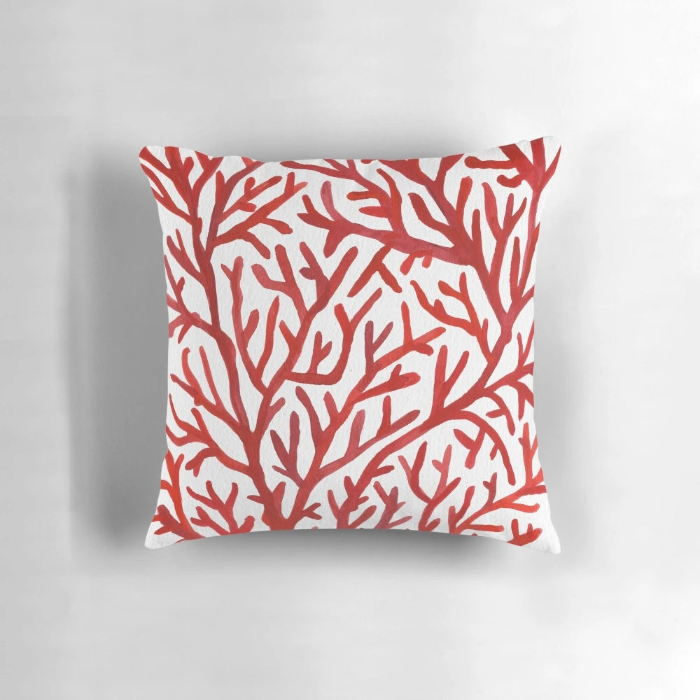 Red and gold watercolor coral design on a decorative throw pillow