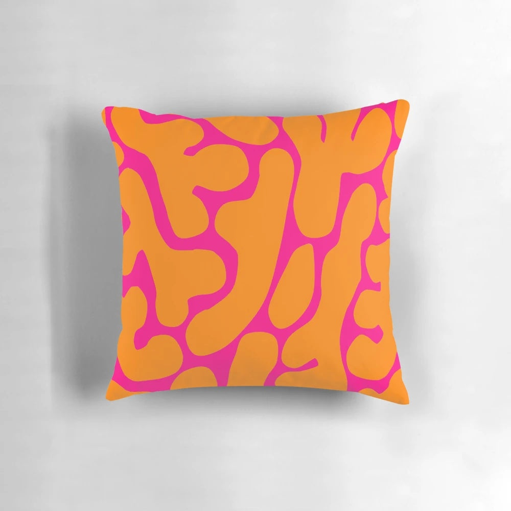 Preppy coral reef pattern in shades of pink and orange on a throw pillow