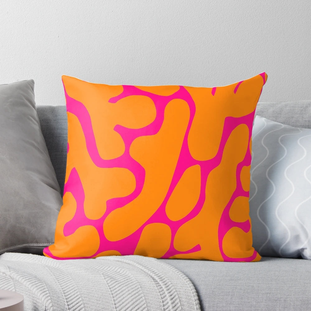 Preppy coral reef pattern in shades of pink and orange on a throw pillow