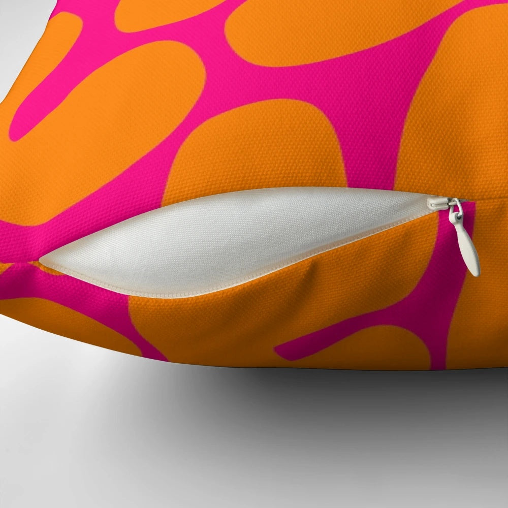 Preppy coral reef pattern in shades of pink and orange on a throw pillow