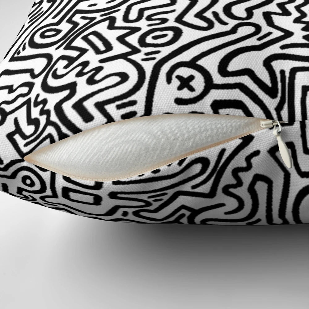 A black and white pillow with abstract dancing figures, evoking a modern, artistic aesthetic.