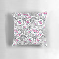 Pillow featuring a watercolor design of dinosaurs and roses in white, pink, and shades of green.