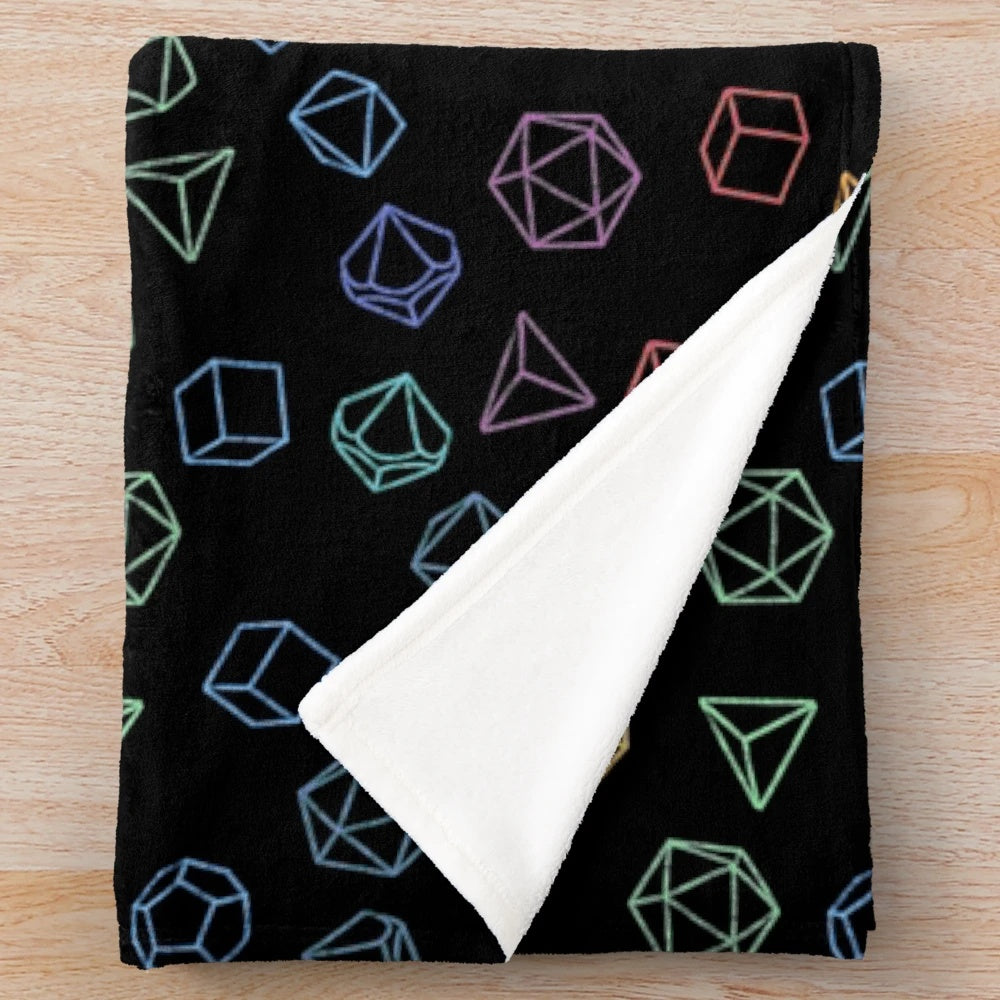 A cozy plush blanket featuring a rainbow pattern of Dungeons and Dragons dice on a black background.