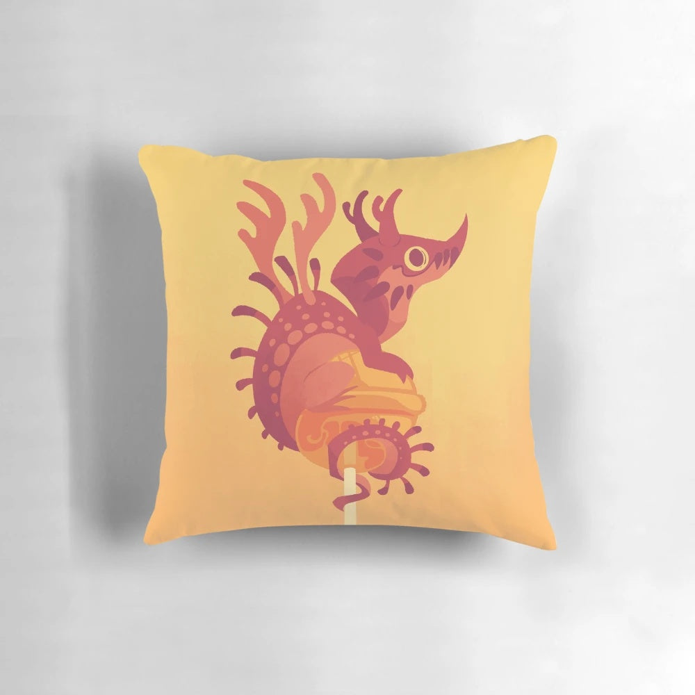 Colorful decorative pillow featuring a whimsical dragon alebrije design in shades of cherry and orange