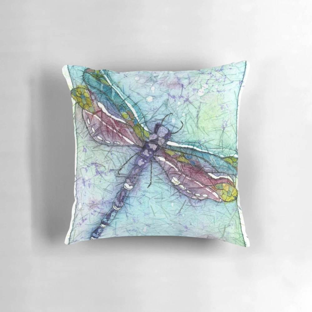 Vibrant watercolor painting of a dragonfly on a decorative throw pillow
