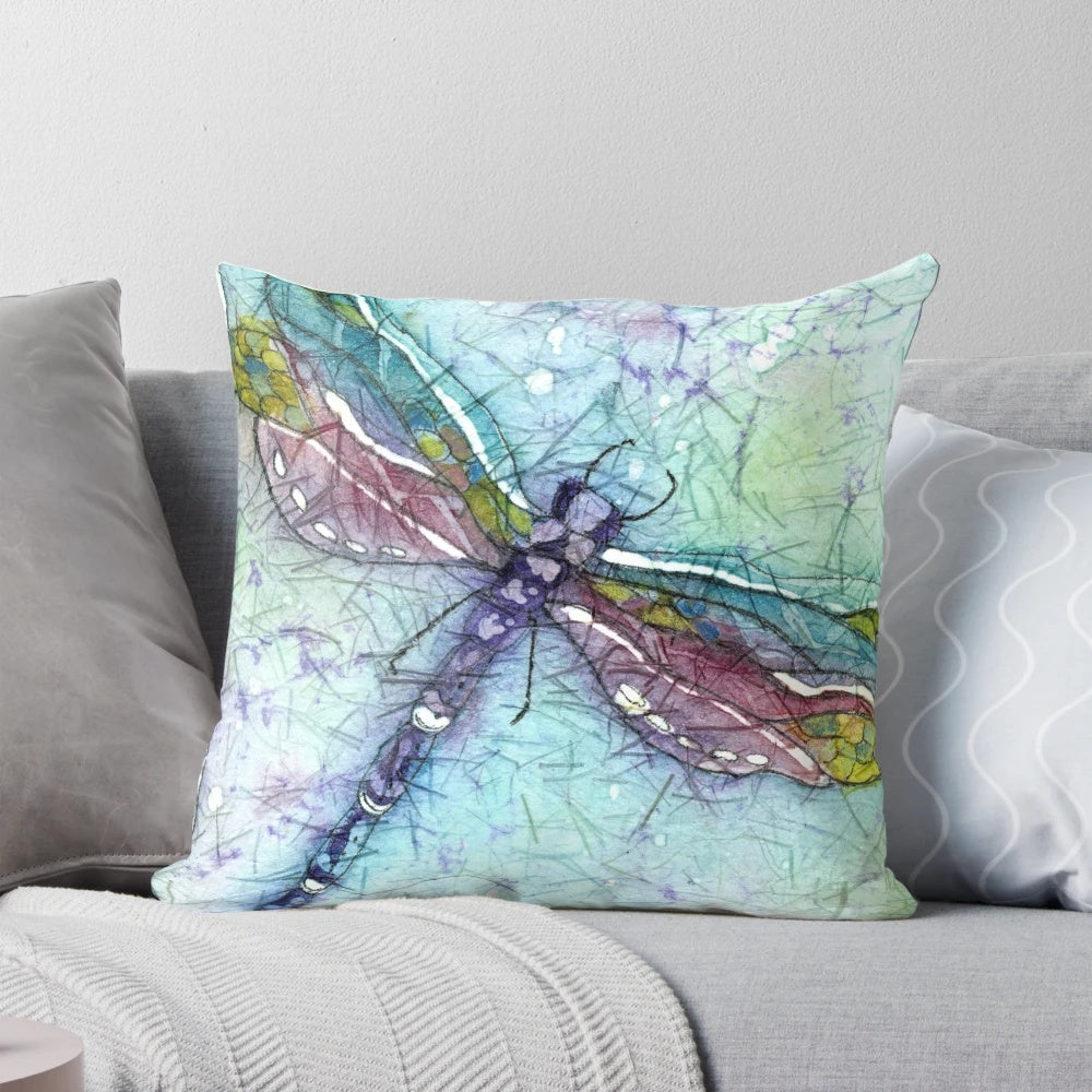 Vibrant watercolor painting of a dragonfly on a decorative throw pillow