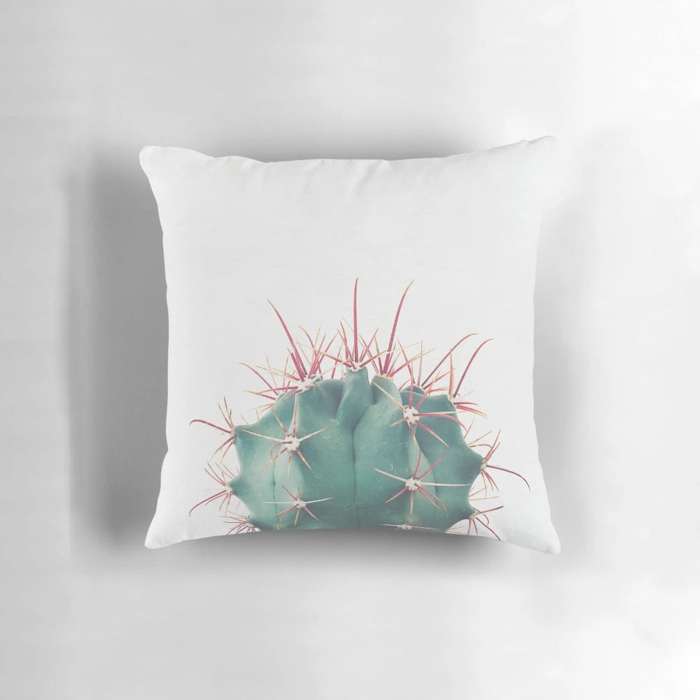 Colorful Ferocactus cactus pillow with vibrant green and red spines against a neutral background