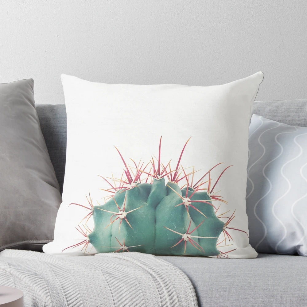 Colorful Ferocactus cactus pillow with vibrant green and red spines against a neutral background