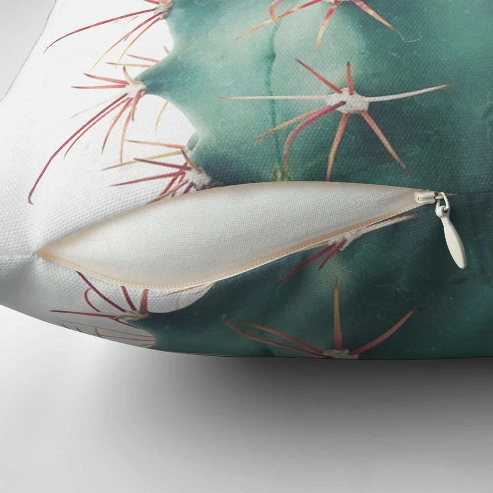 Colorful Ferocactus cactus pillow with vibrant green and red spines against a neutral background