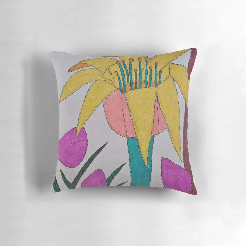 Colorful pillow with a vibrant floral design featuring a flower in a field of grass and petals.