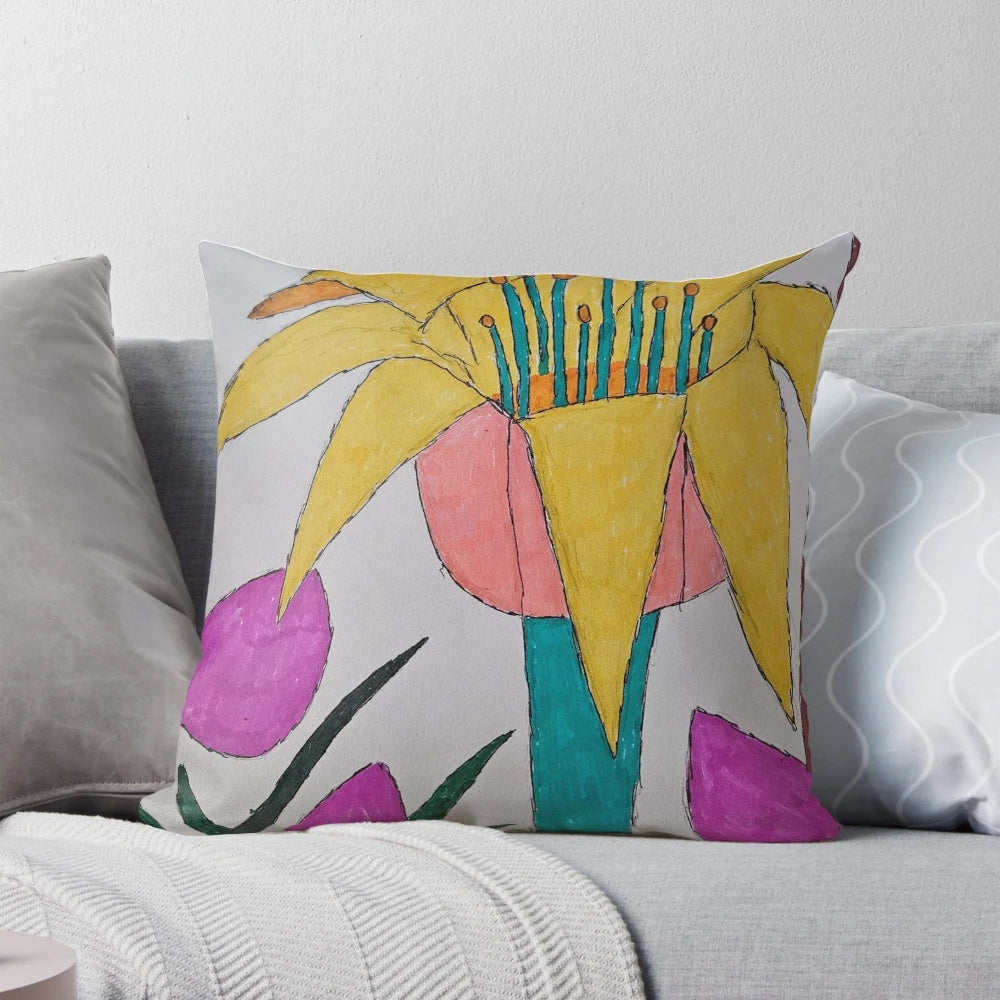 Colorful pillow with a vibrant floral design featuring a flower in a field of grass and petals.