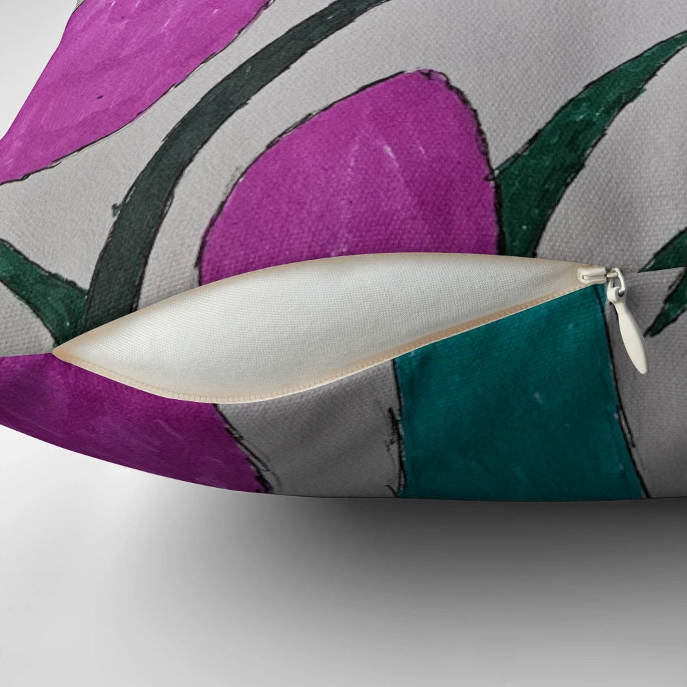 Colorful pillow with a vibrant floral design featuring a flower in a field of grass and petals.