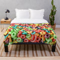Colorful plush blanket featuring a playful fruit cereal pattern
