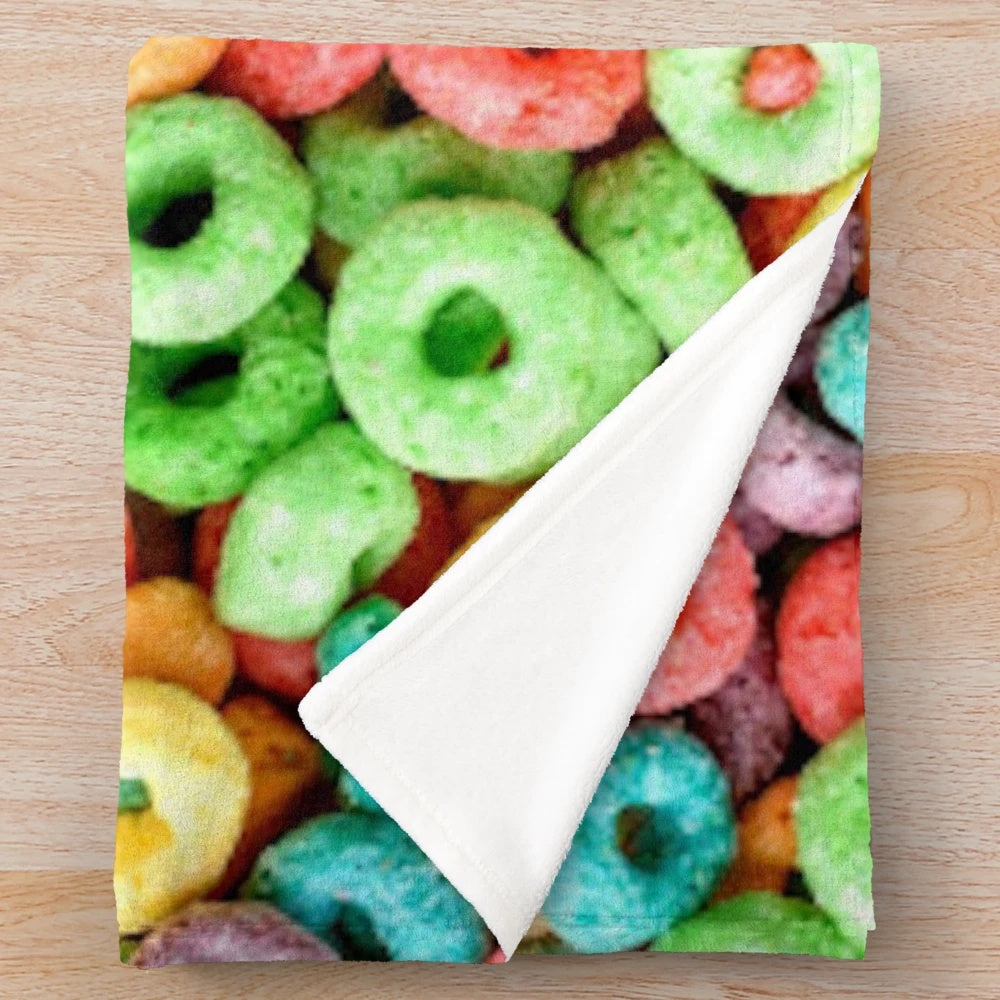 Colorful plush blanket featuring a playful fruit cereal pattern