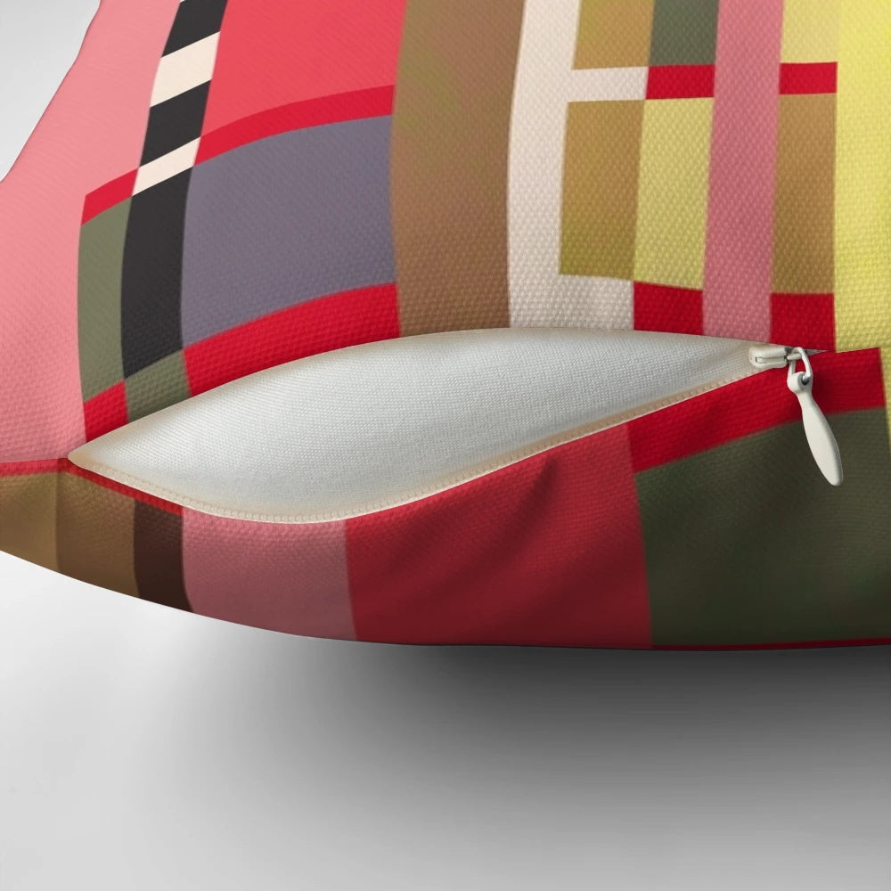 Geometric patterned throw pillow in bright orange, red, and white inspired by Bauhaus design