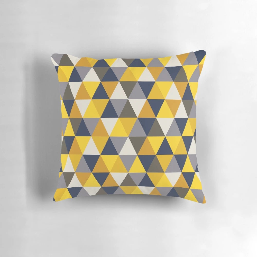 A grey, blue, and mustard yellow geometric pillow with triangles and hexagons, perfect for adding a touch of modern style to any room.