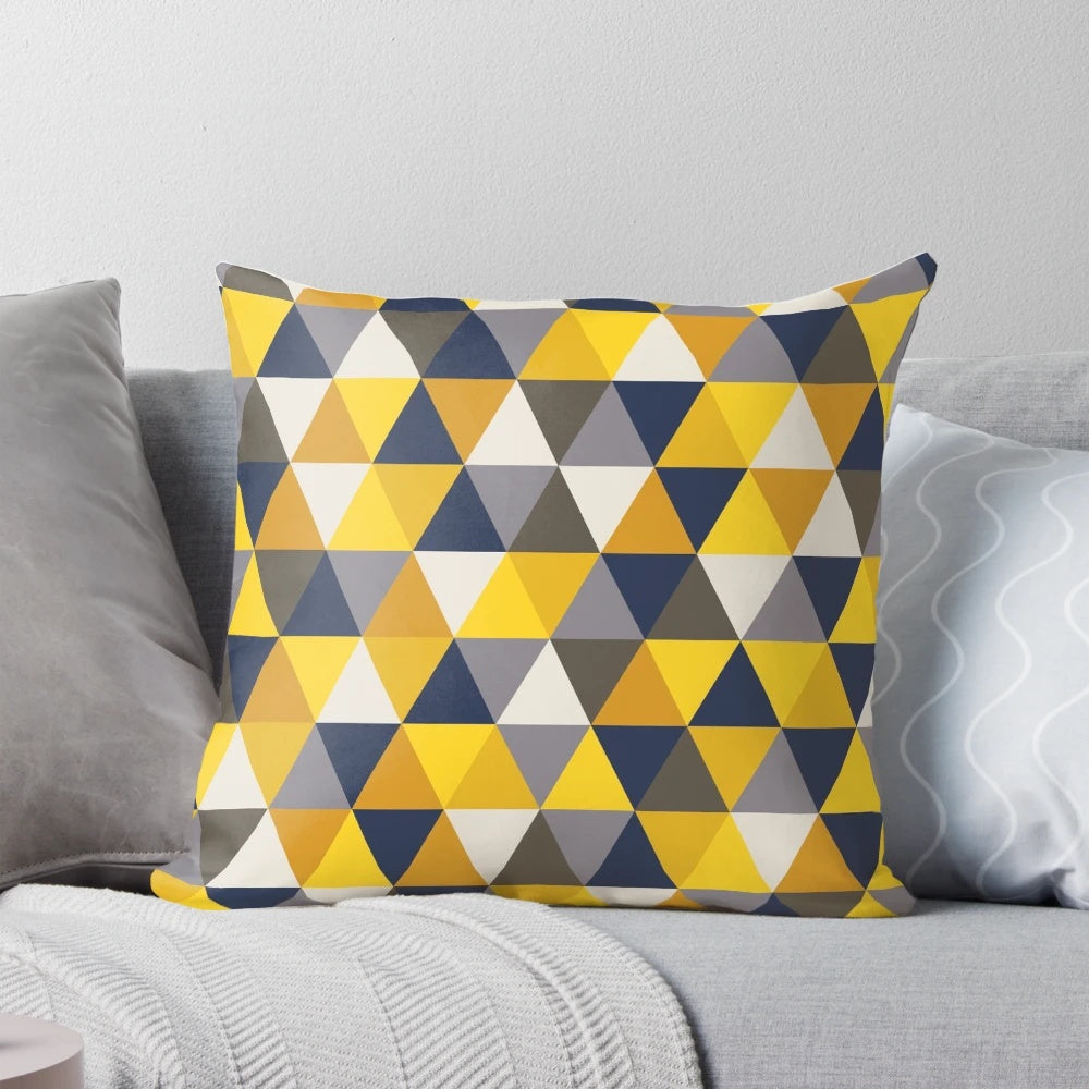 A grey, blue, and mustard yellow geometric pillow with triangles and hexagons, perfect for adding a touch of modern style to any room.