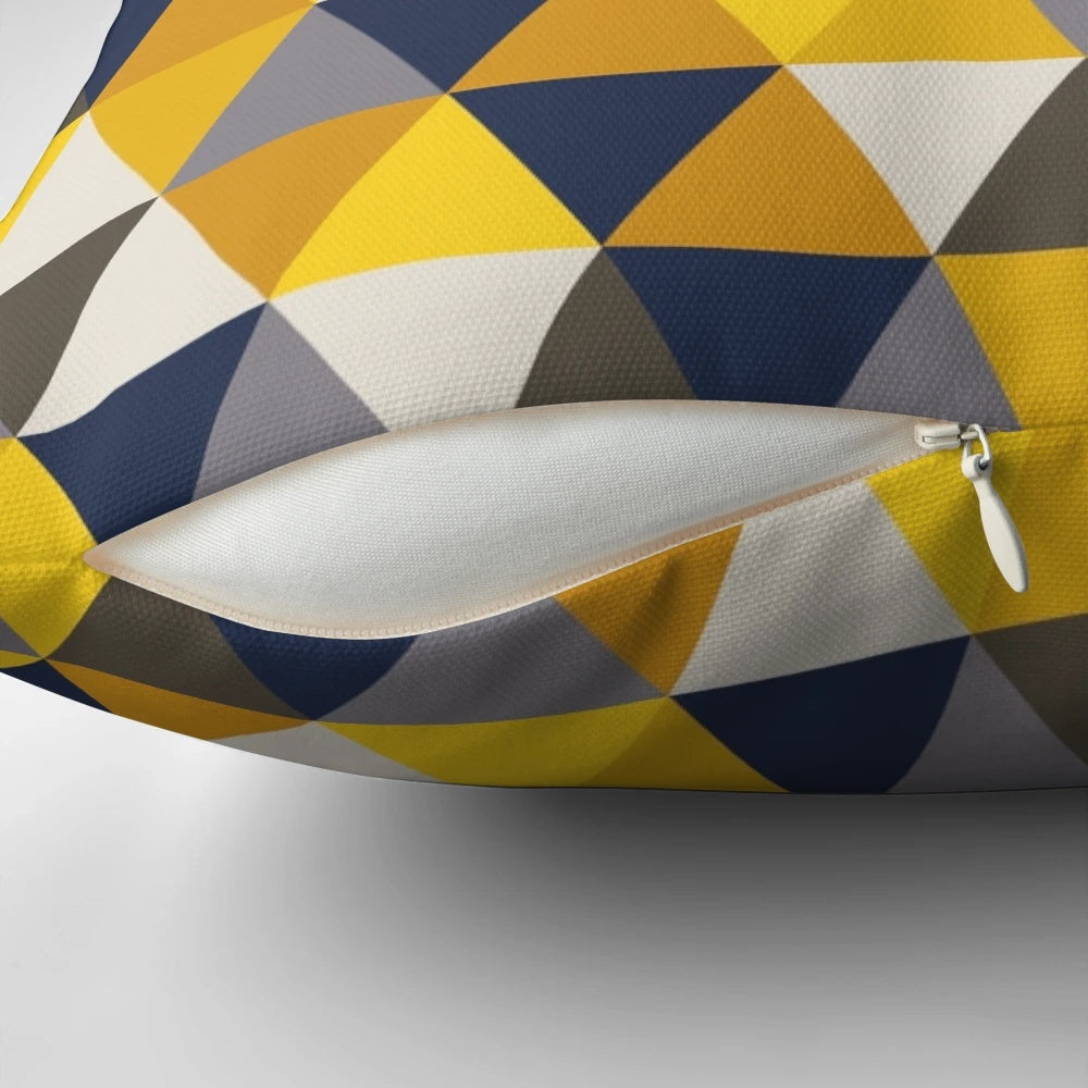 A grey, blue, and mustard yellow geometric pillow with triangles and hexagons, perfect for adding a touch of modern style to any room.