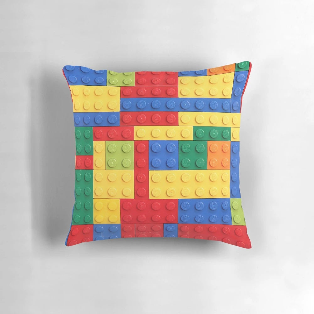 Colorful pillow featuring a geometric building block design in blue, red, yellow, and green