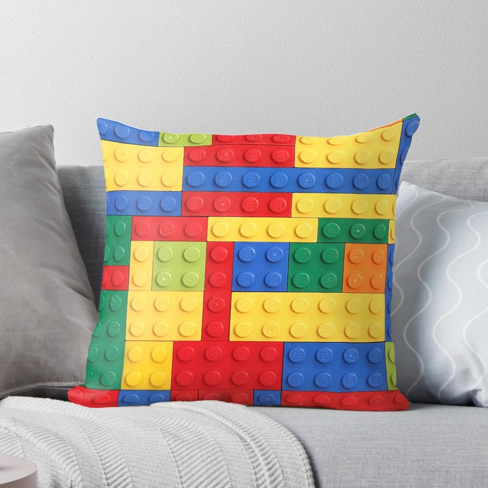 Colorful pillow featuring a geometric building block design in blue, red, yellow, and green