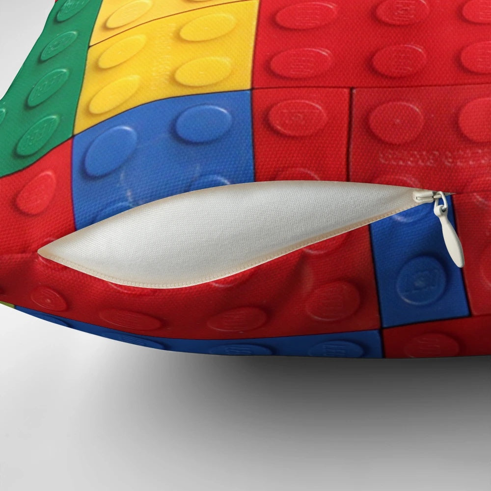 Colorful pillow featuring a geometric building block design in blue, red, yellow, and green