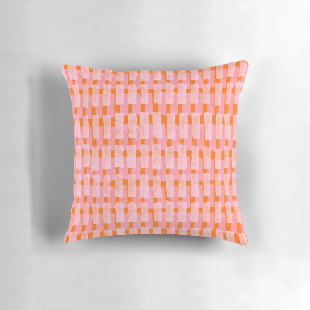 Geometric throw pillow in pink and orange with abstract brush stroke patterns