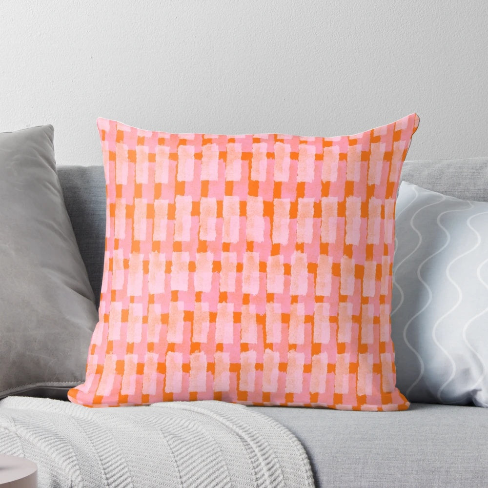 Geometric throw pillow in pink and orange with abstract brush stroke patterns