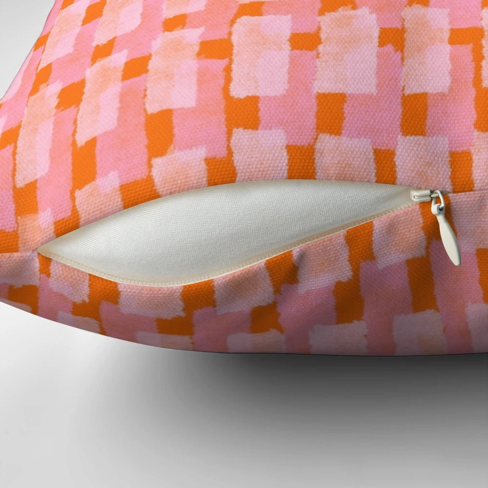 Geometric throw pillow in pink and orange with abstract brush stroke patterns