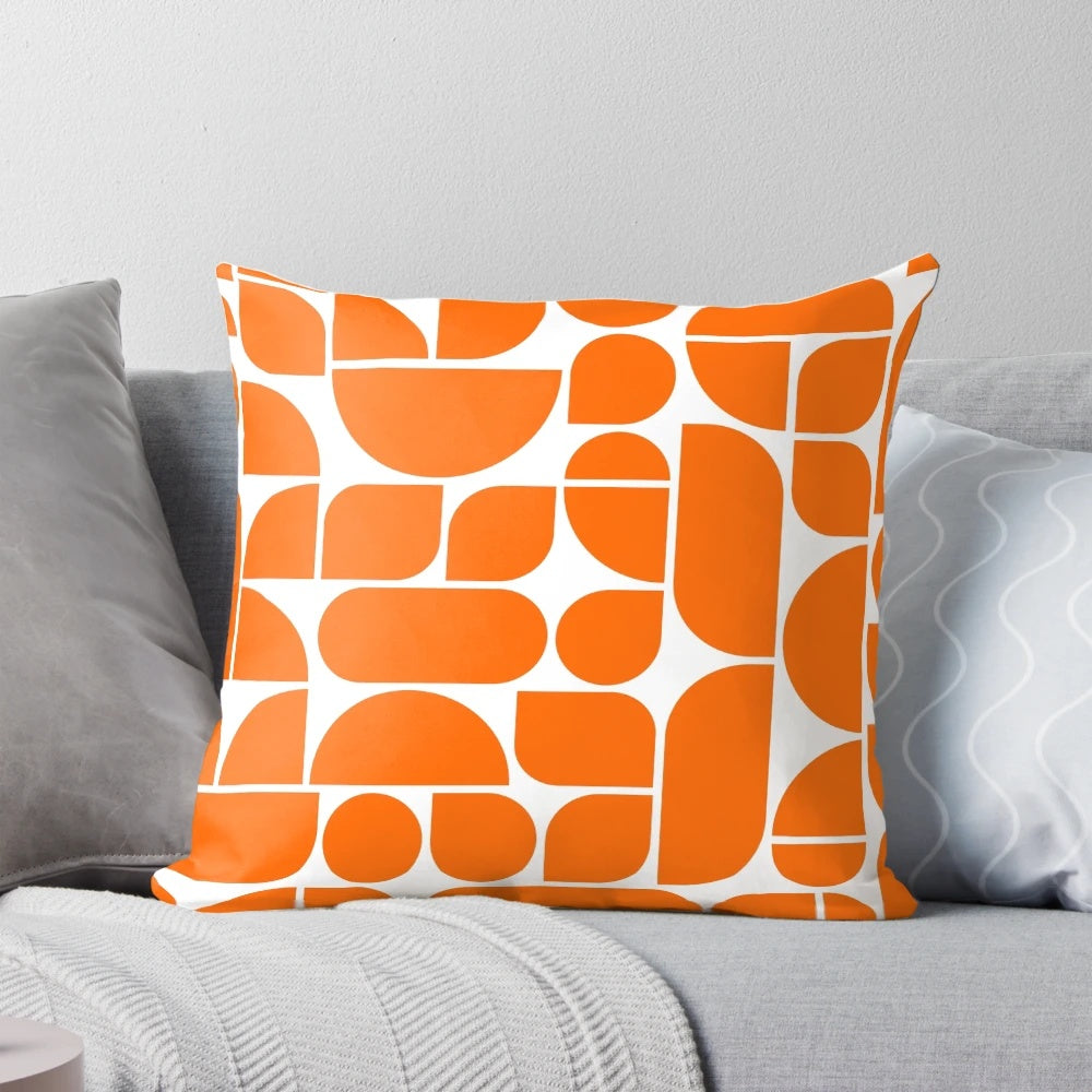 Vibrant orange throw pillow with abstract geometric shapes, inspired by mid-century modern and Scandinavian design.