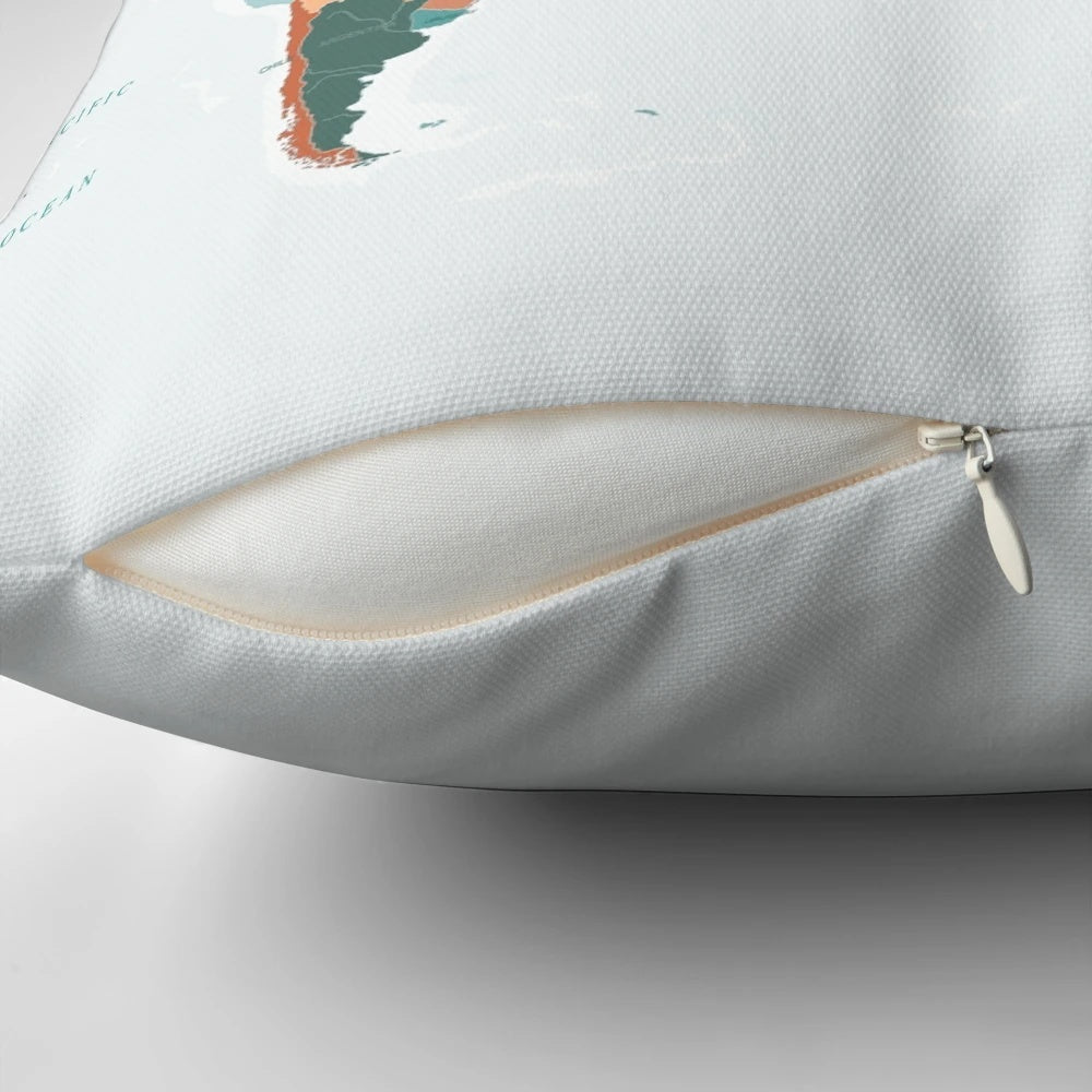 Decorative pillow featuring a vibrant world map design in burnt orange and teal colors