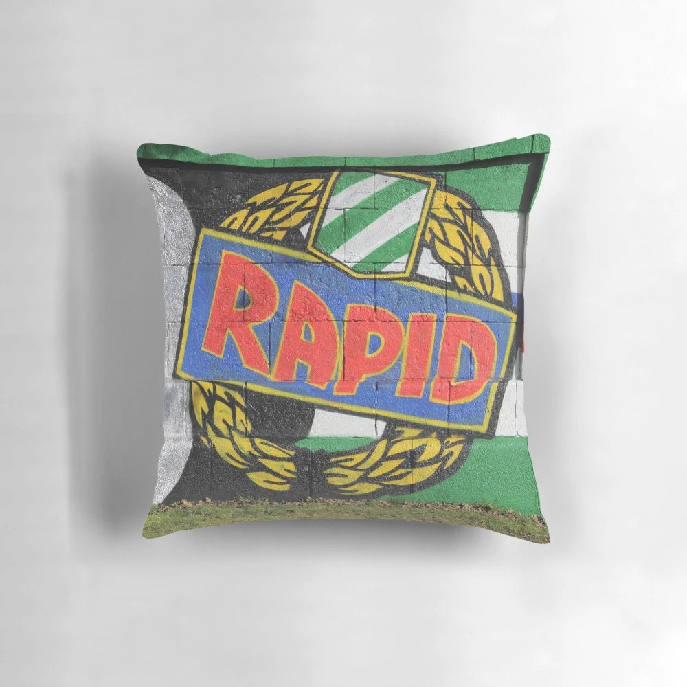 Colorful graffiti-style pillow featuring the Rapid Wien soccer club logo and fans' "Rapid ist meine religion" slogan.