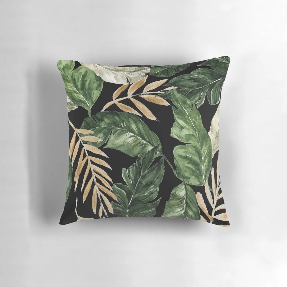 Pillow featuring a vibrant pattern of green and golden leaves against a black background.
