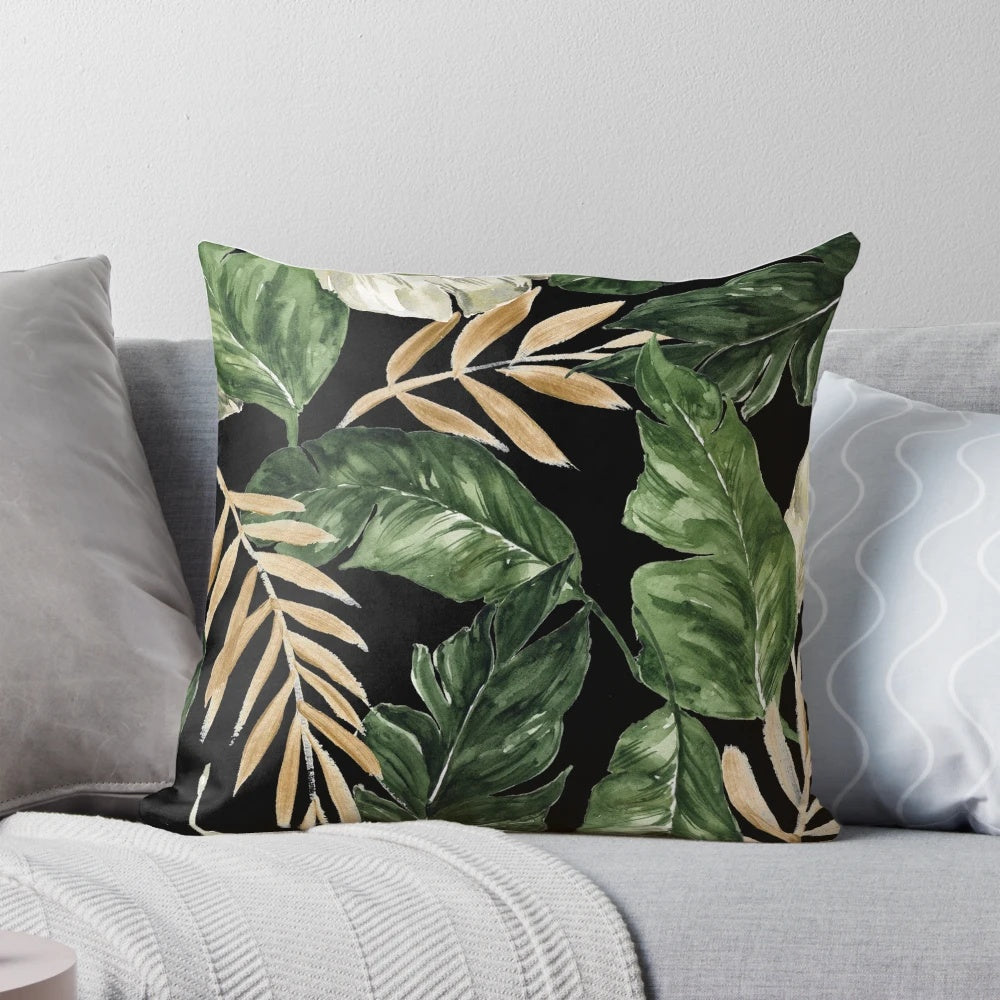 Pillow featuring a vibrant pattern of green and golden leaves against a black background.