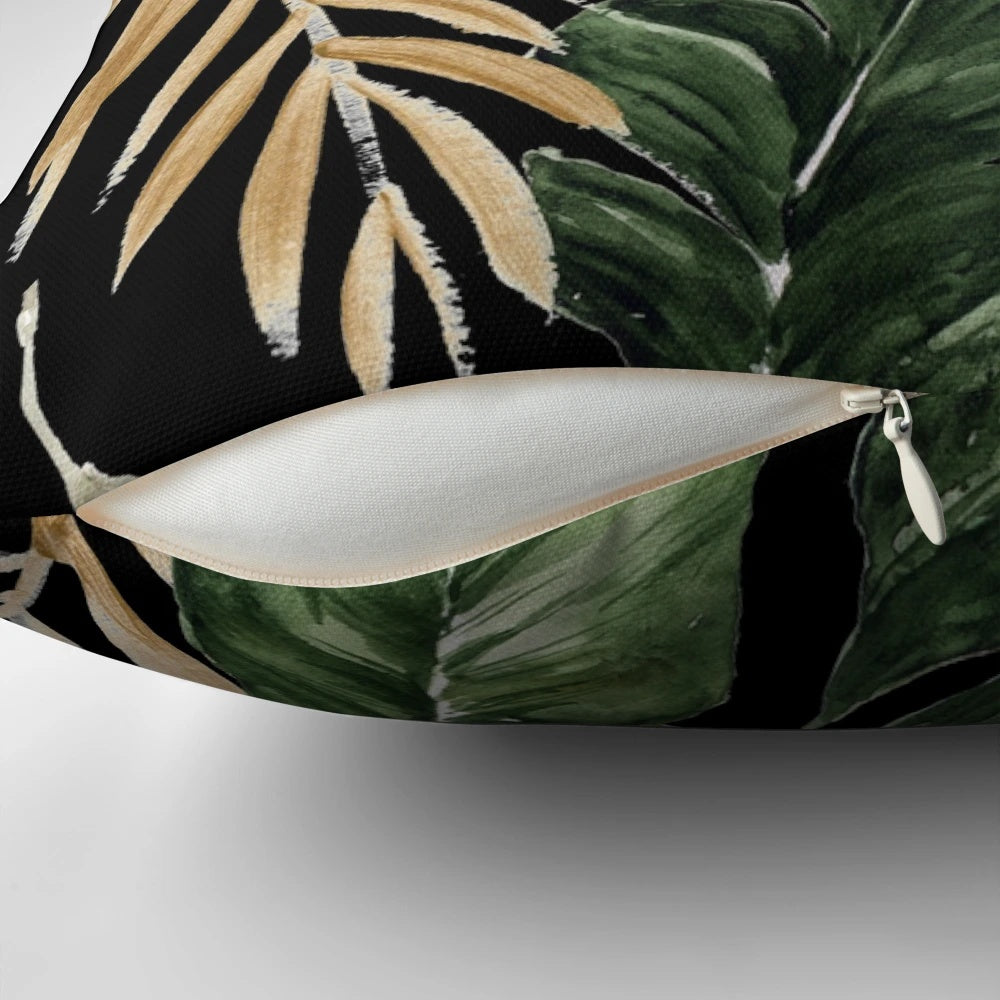 Pillow featuring a vibrant pattern of green and golden leaves against a black background.