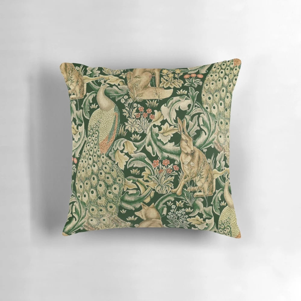 Decorative pillow featuring a vibrant green forest scene with peacocks, foxes, and hares surrounded by lush botanical prints and floral patterns.