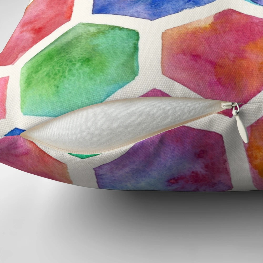 A colorful throw pillow featuring a hand-painted watercolor honeycomb pattern design in blue, red, green, pink, and purple tones.