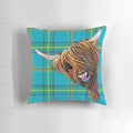 Colorful and cozy decorative pillow featuring a friendly highland cow against a tartan pattern background.