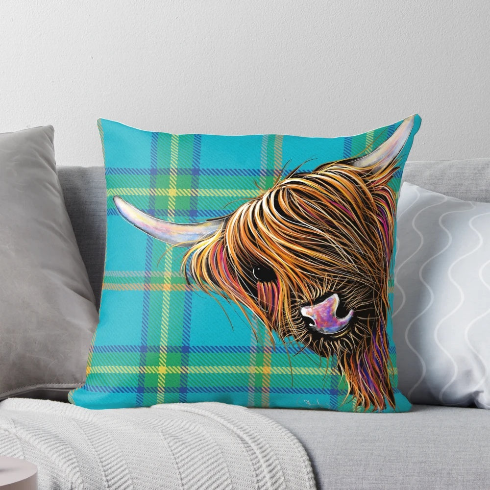 Colorful and cozy decorative pillow featuring a friendly highland cow against a tartan pattern background.