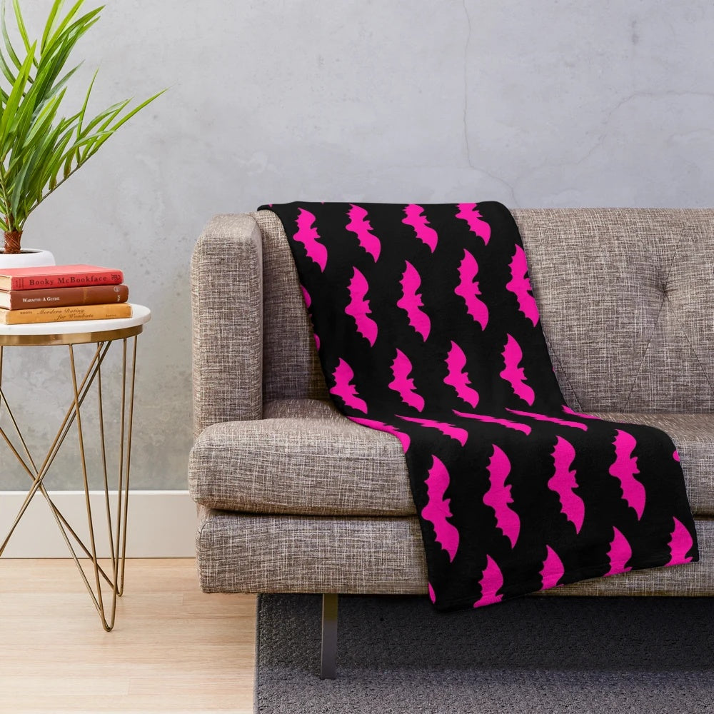 Plush blanket with a spooky bat tile pattern in hot pink and black
