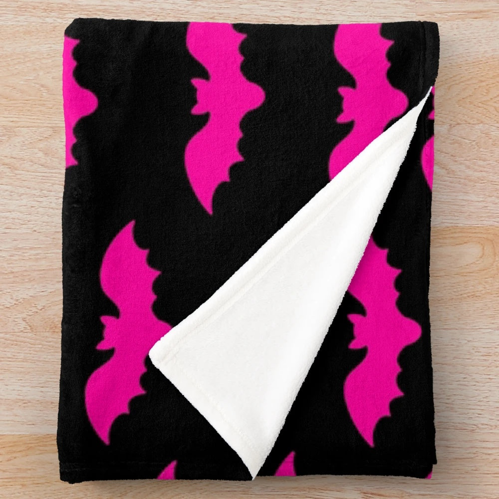 Plush blanket with a spooky bat tile pattern in hot pink and black