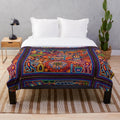 Colorful Huichol-inspired plush blanket with abstract skull and floral patterns
