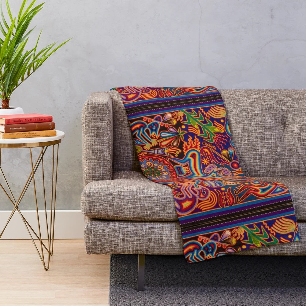 Colorful Huichol-inspired plush blanket with abstract skull and floral patterns