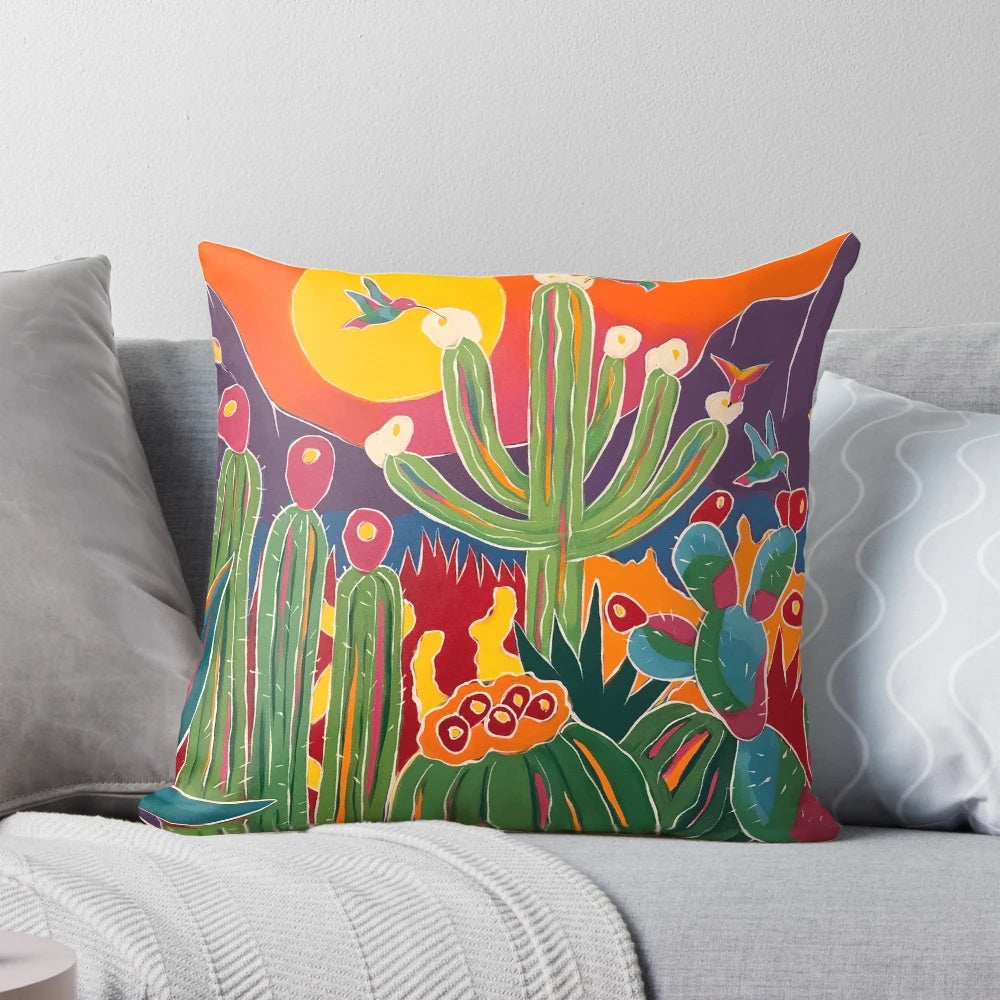 A decorative throw pillow featuring a hummingbird perched on a cactus, set against a vibrant desert landscape.