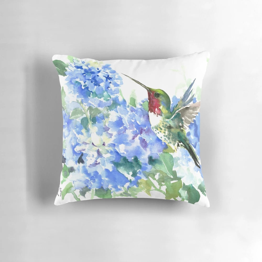 Colorful watercolor painting of a hummingbird hovering over vibrant hydrangea flowers in shades of blue.