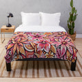 Tropical floral pattern plush blanket in warm tones of pink and orange