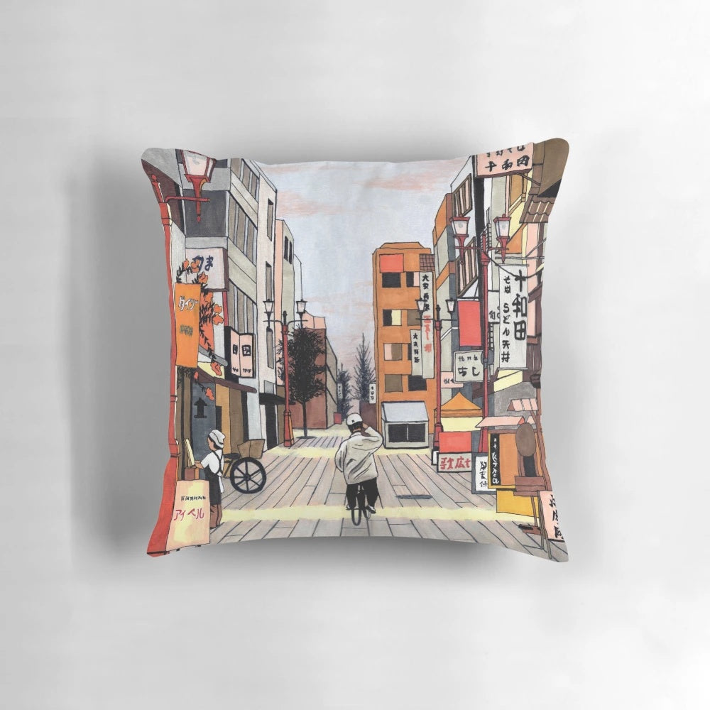 Colorful pillow featuring an anime-inspired illustration of an early morning bicycle ride through a modern Japanese cityscape