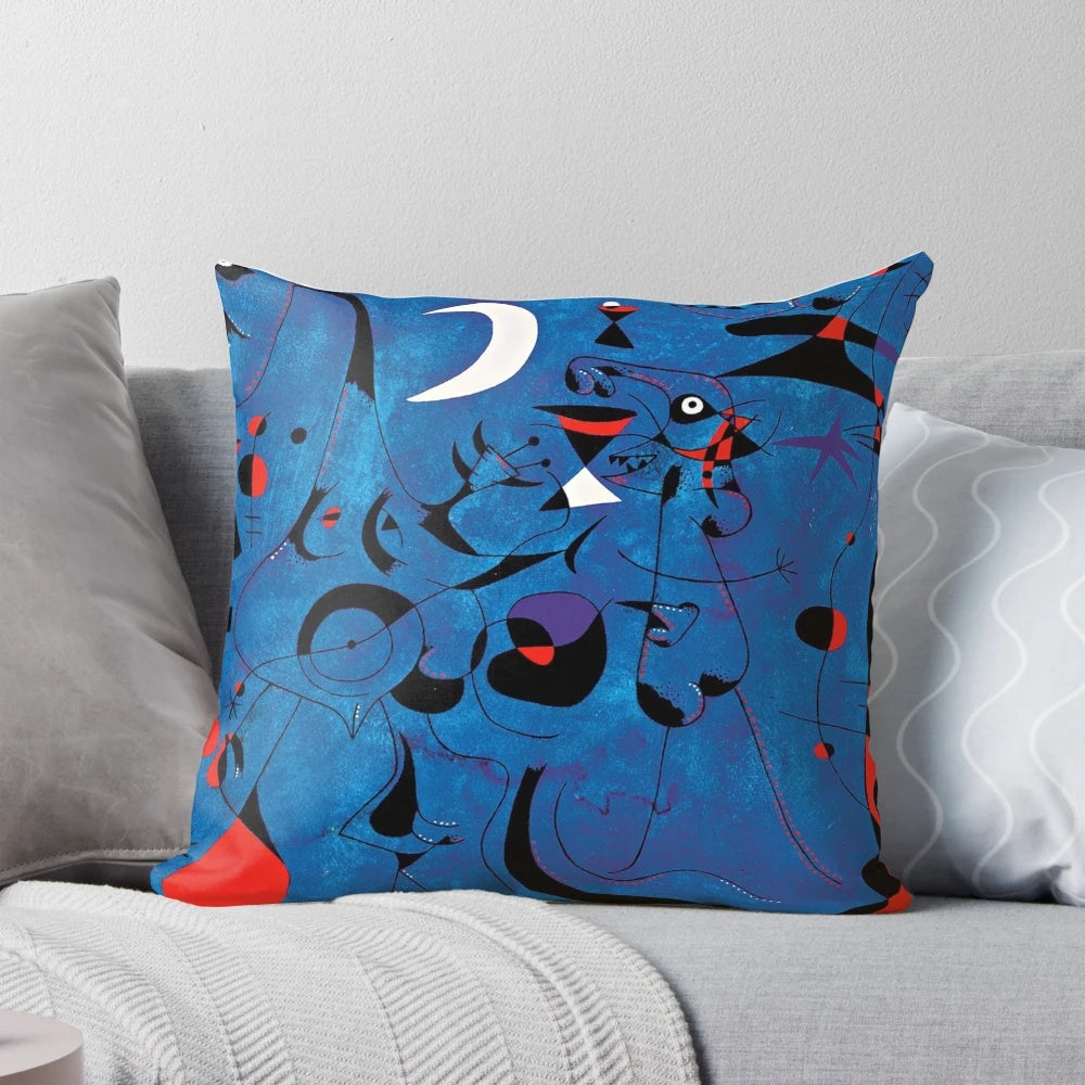 A decorative pillow featuring abstract blue and red geometric shapes inspired by the artwork of renowned surrealist painter Joan Miro.