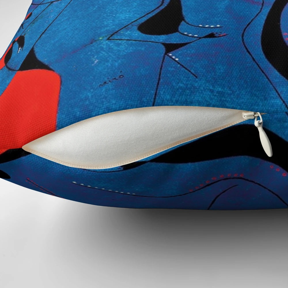 A decorative pillow featuring abstract blue and red geometric shapes inspired by the artwork of renowned surrealist painter Joan Miro.