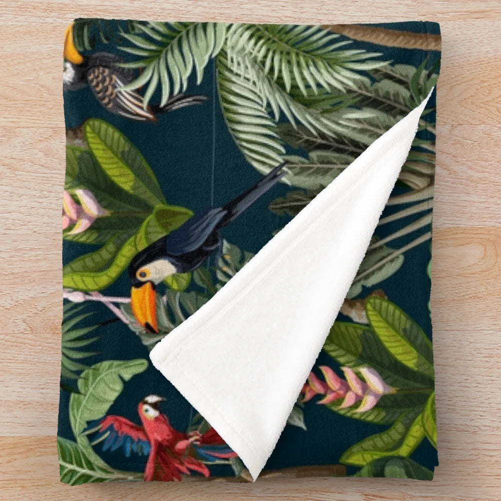 Colorful plush blanket featuring a jungle pattern with toucans, flamingos, and parrots