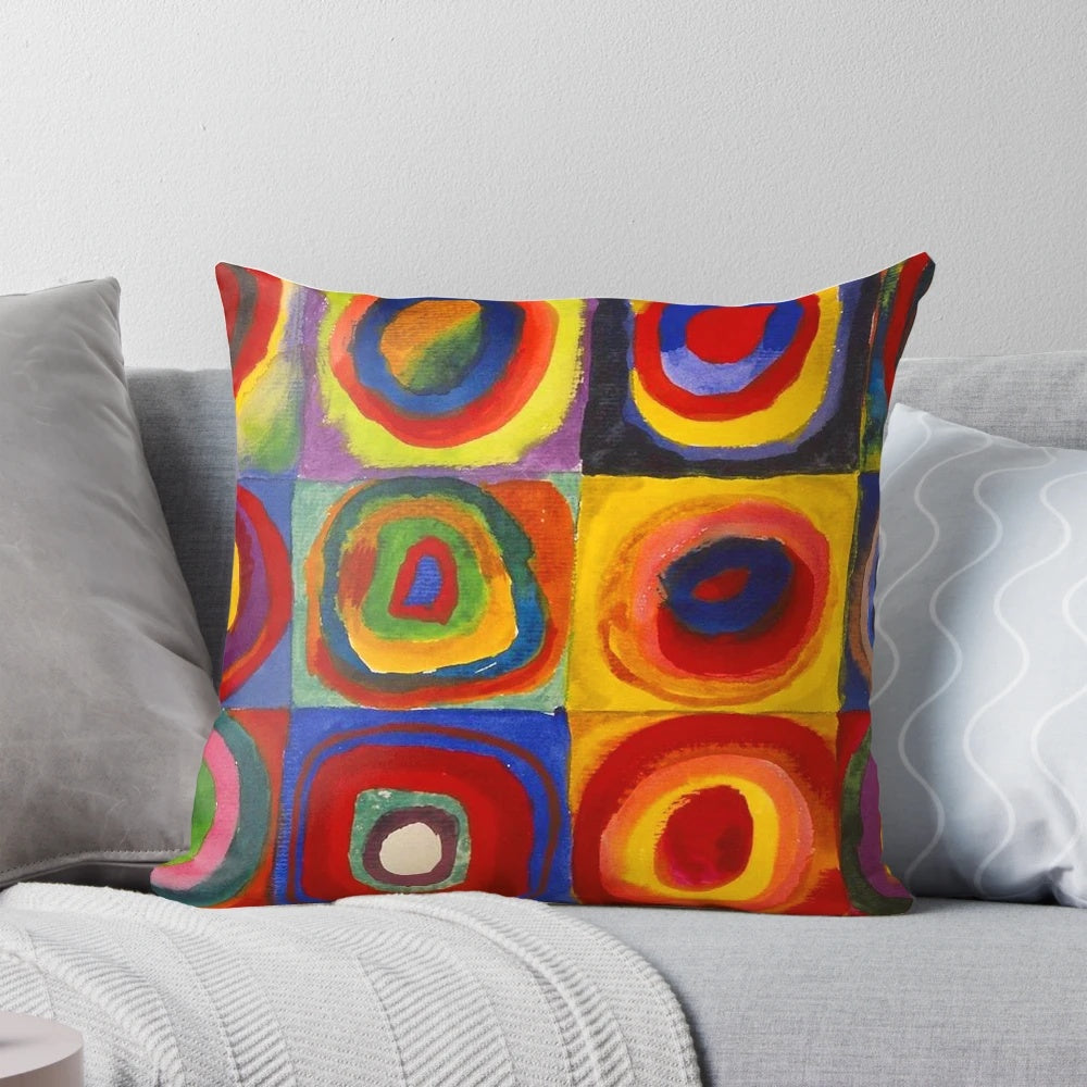Colorful abstract pillow featuring a design of concentric squares and circles in a variety of bright hues, inspired by the artwork of Wassily Kandinsky.